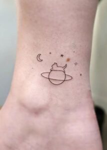 Tatuagem Minimalista de gato em saturno no tornozelo