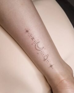 Tatuagem Minimalista de planeta e lua no braço