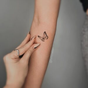 Tatuagem Minimalista de borboleta no antebraço