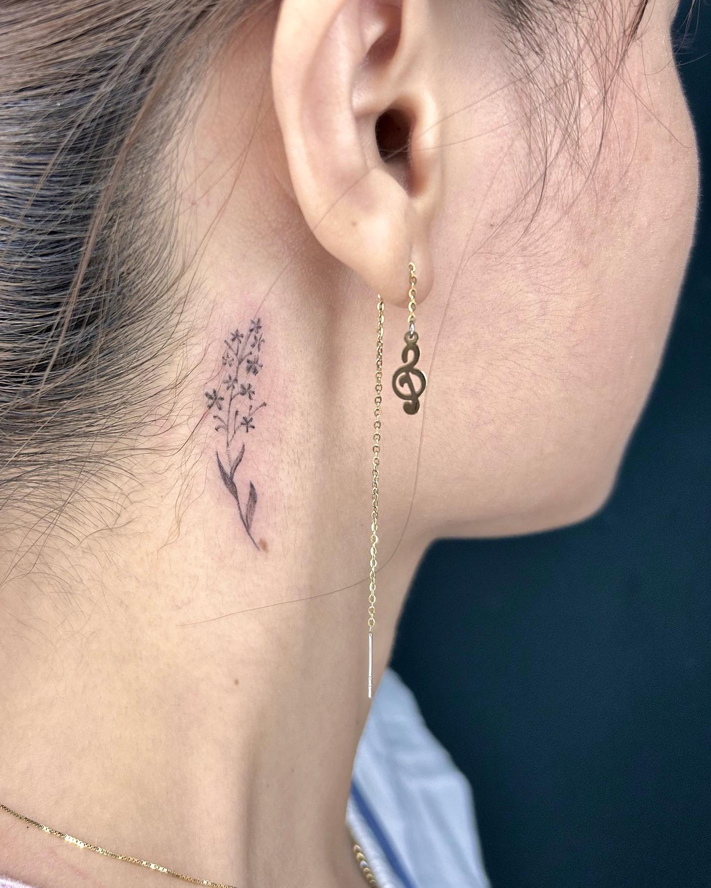 Tatuagem Minimalista de flores atrás da orelha