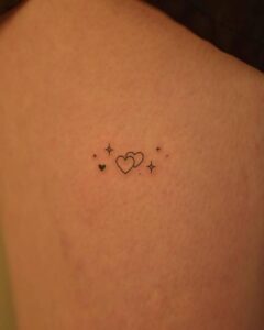 Tatuagem Minimalista de corações e estrelas no ombro