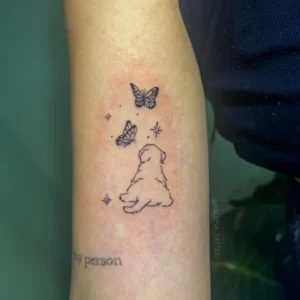 Tatuagem Minimalista de cachorro e borboletas no braço