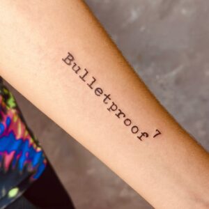 Tatuagem Minimalista palavra Bulletproof no braço