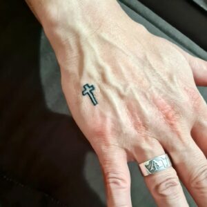 Tatuagem Minimalista de cruz na mão