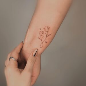 Tatuagem Minimalista de flor delicada no braço
