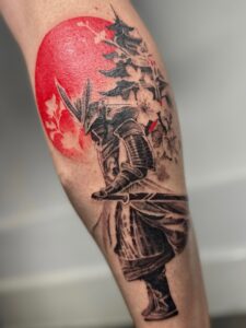 Tatuagem Samurai com lua e flores na perna