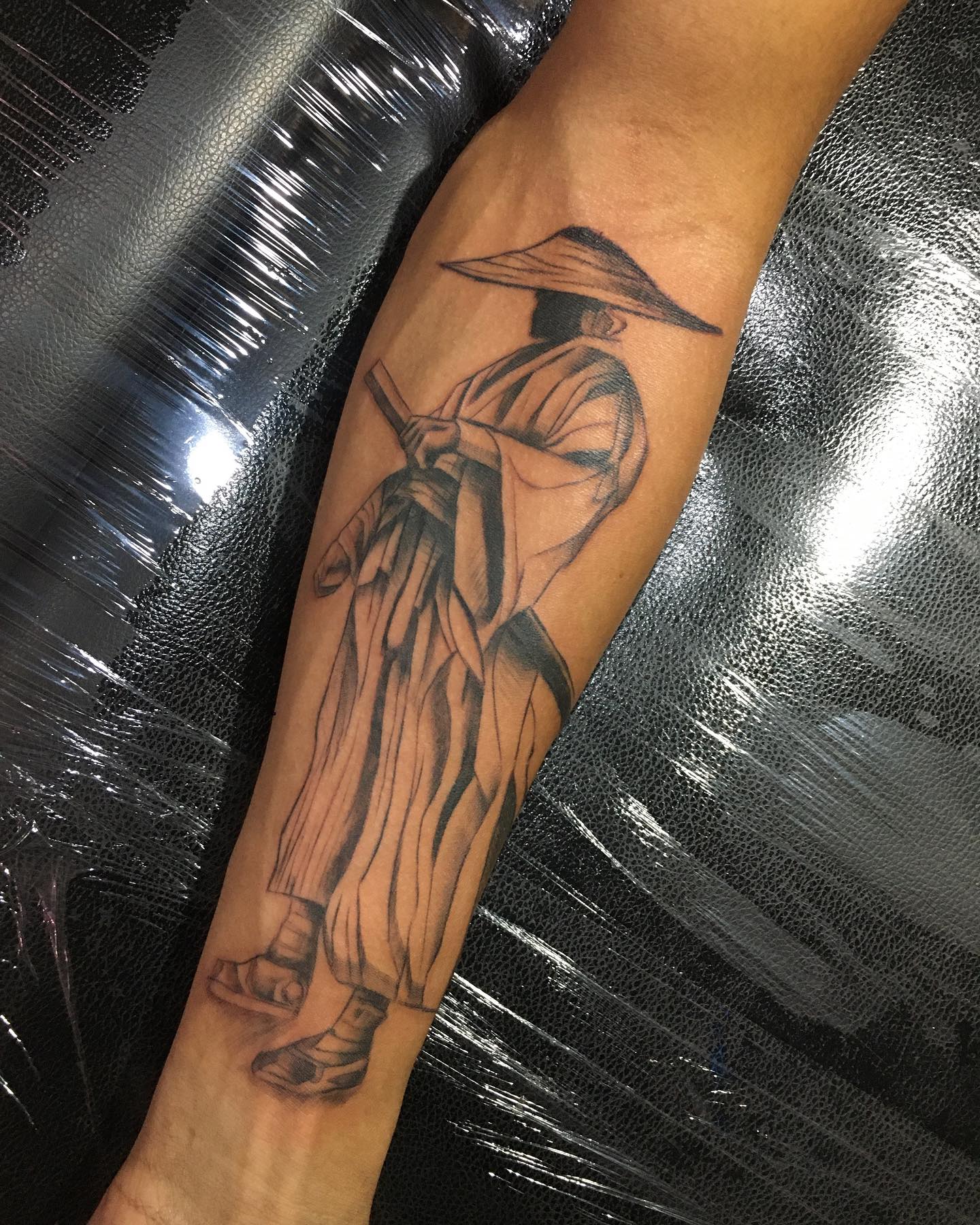 Tatuagem Samurai com chapéu e espada no braço