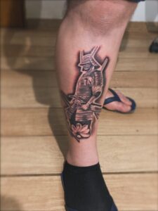 Tatuagem Samurai em pé com flor no tornozelo