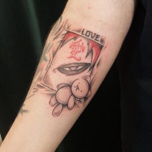 Tatuagem do Gaara com o olho e urso de pelúcia no braço