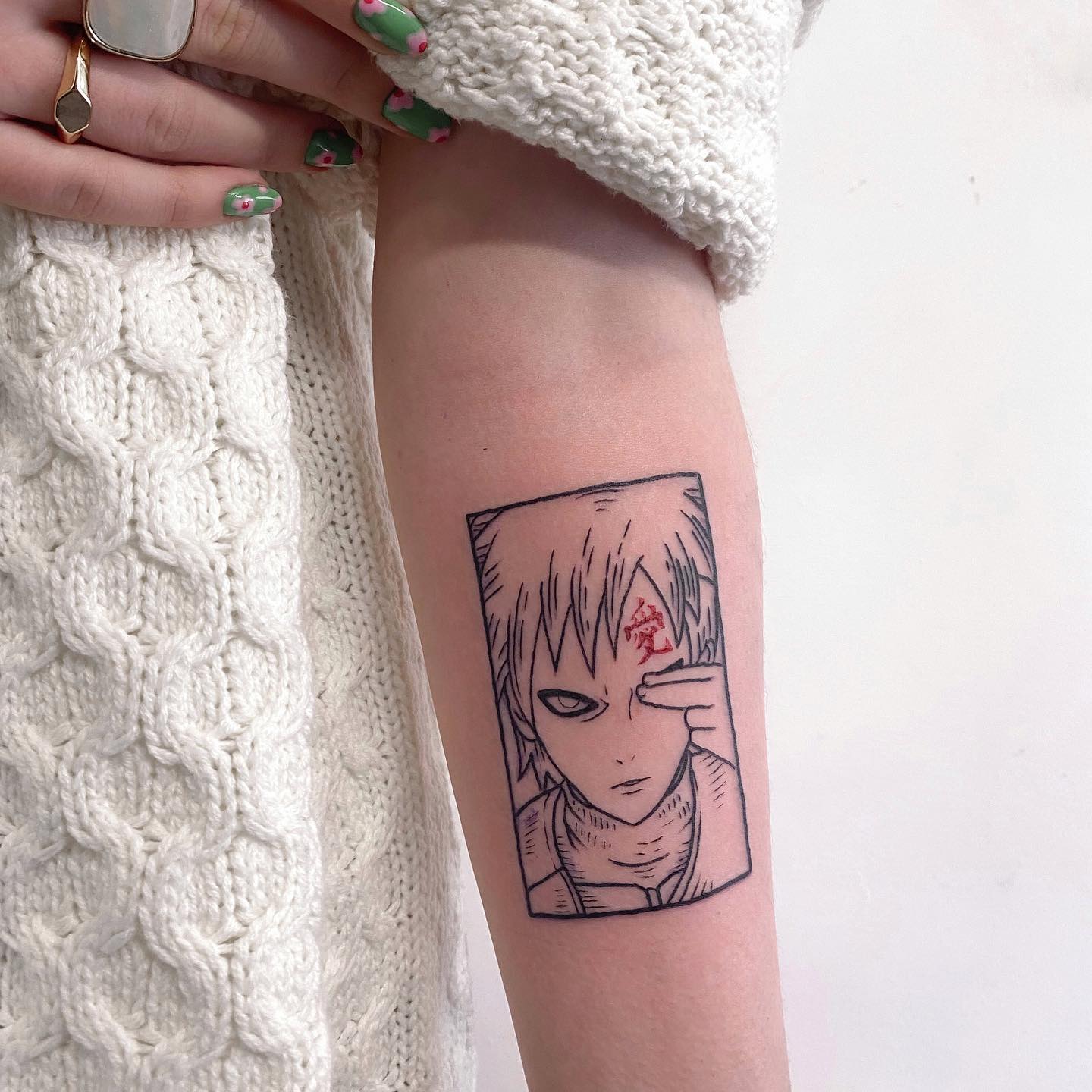 Tatuagem do Gaara com o rosto dele em estilo minimalista no braço