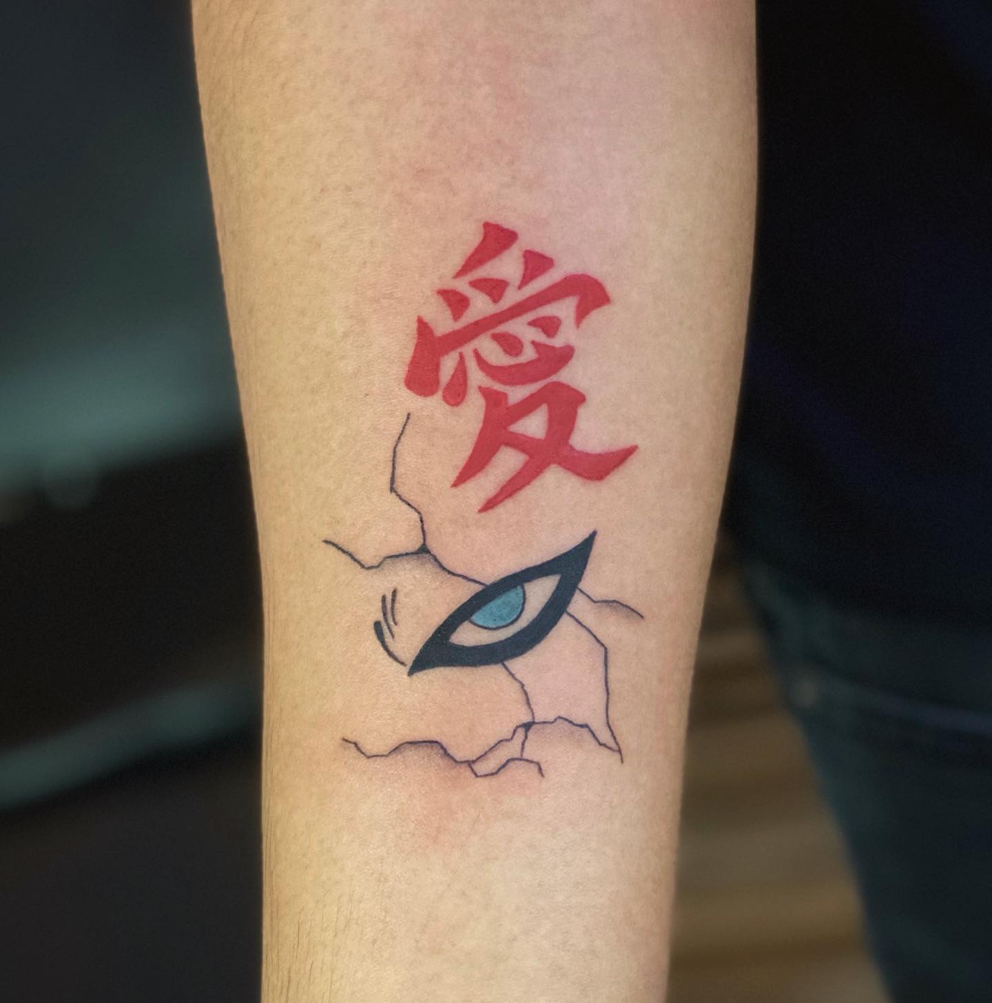 Tatuagem do Gaara com olho e escrita em japonês no braço