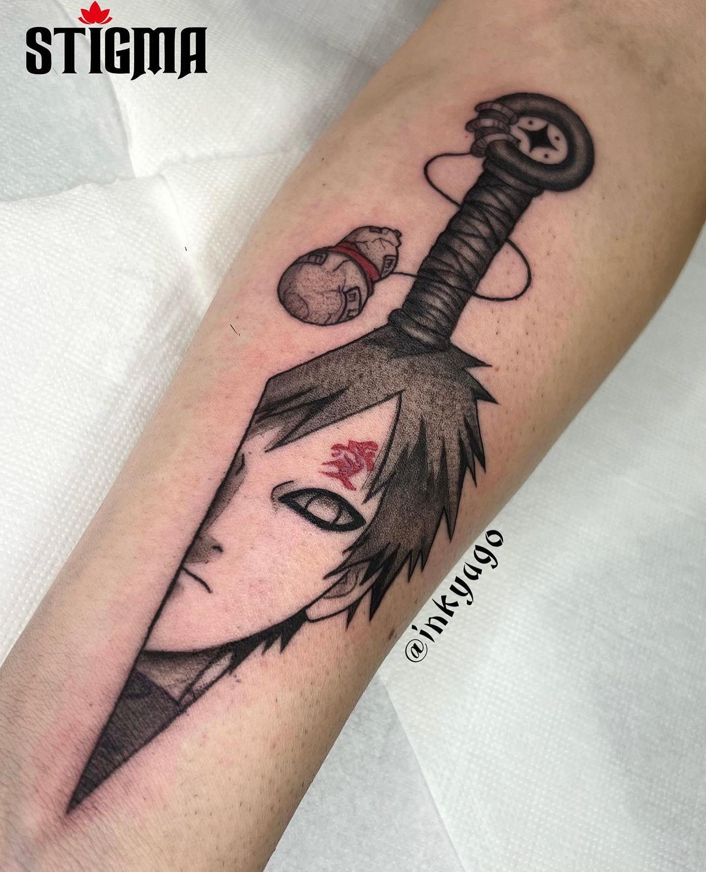 Tatuagem do Gaara com a espada e o rosto no antebraço