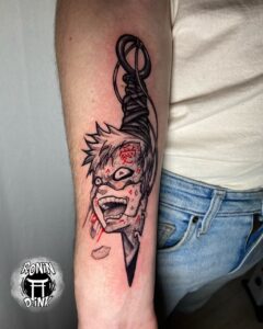 Tatuagem do Gaara com rosto e punhal em detalhe no braço
