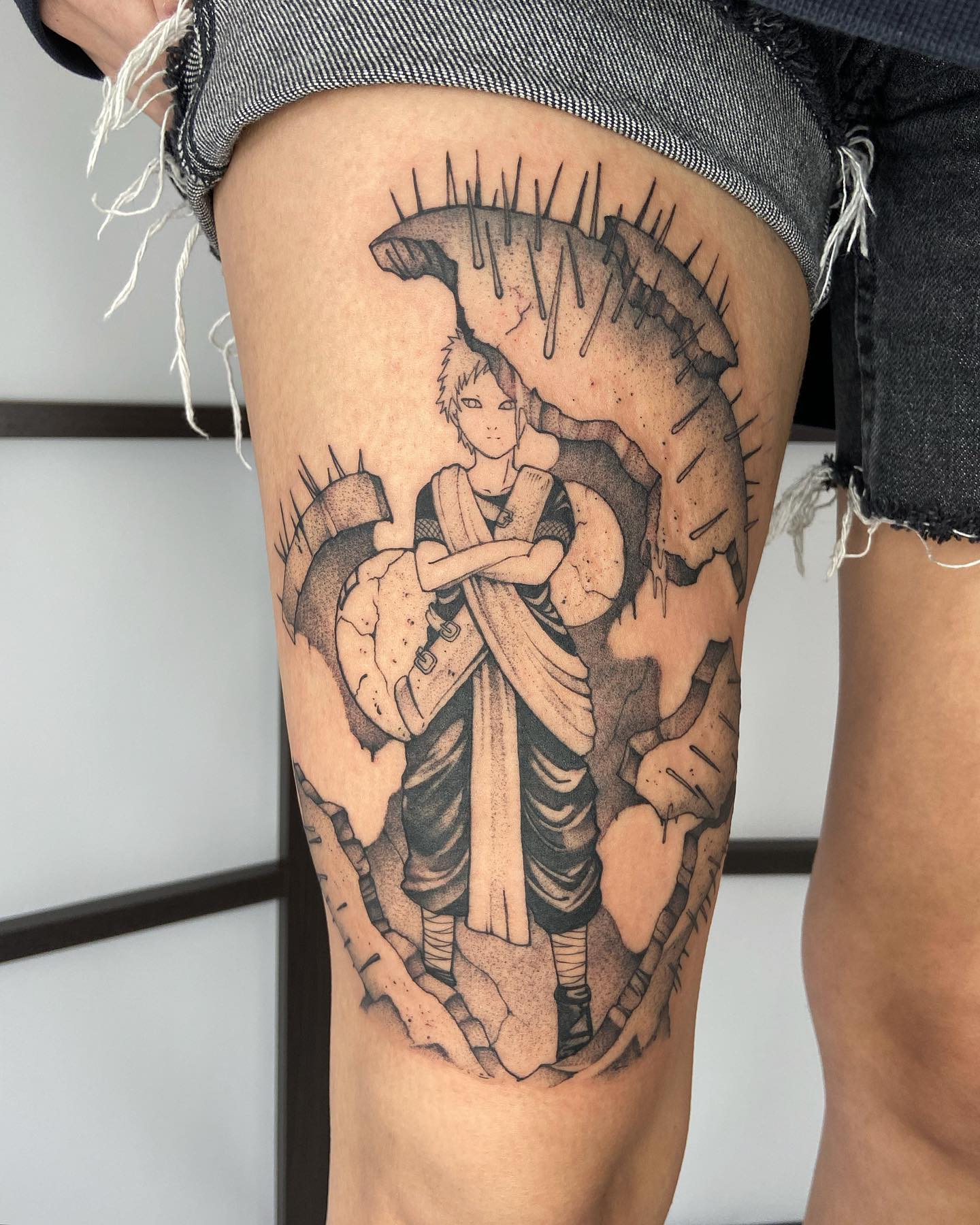 Tatuagem do Gaara estilo grande na coxa com fundo detalhado