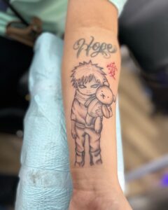 Tatuagem do Gaara segurando um coelho com a palavra Hope