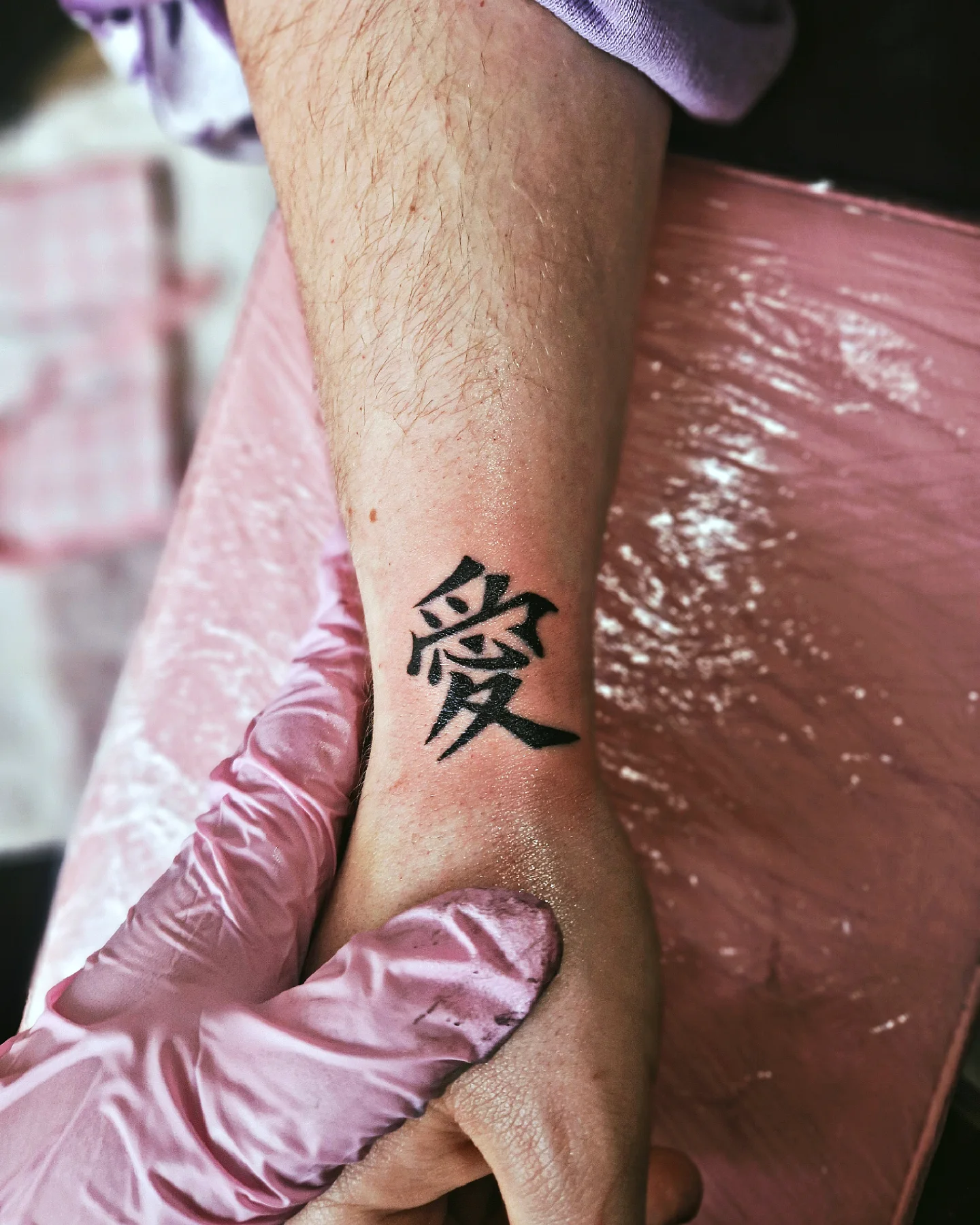 Tatuagem do Gaara com símbolo em escrita estilizada no braço